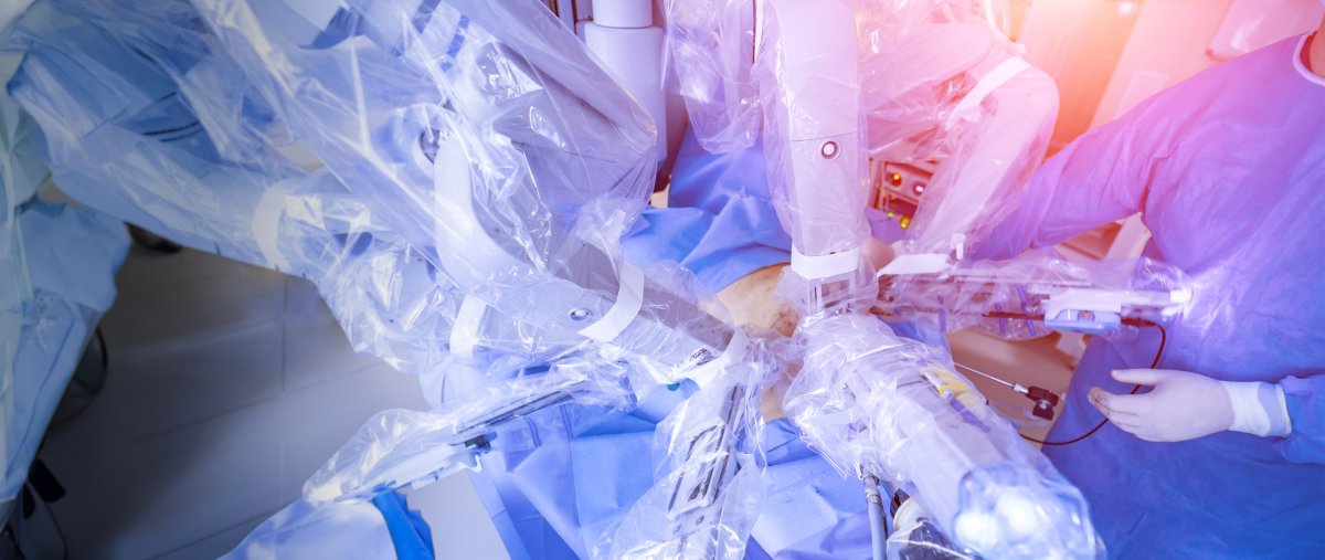 Surgeon's hands performing surgery with a robot-assisted surgical device.
