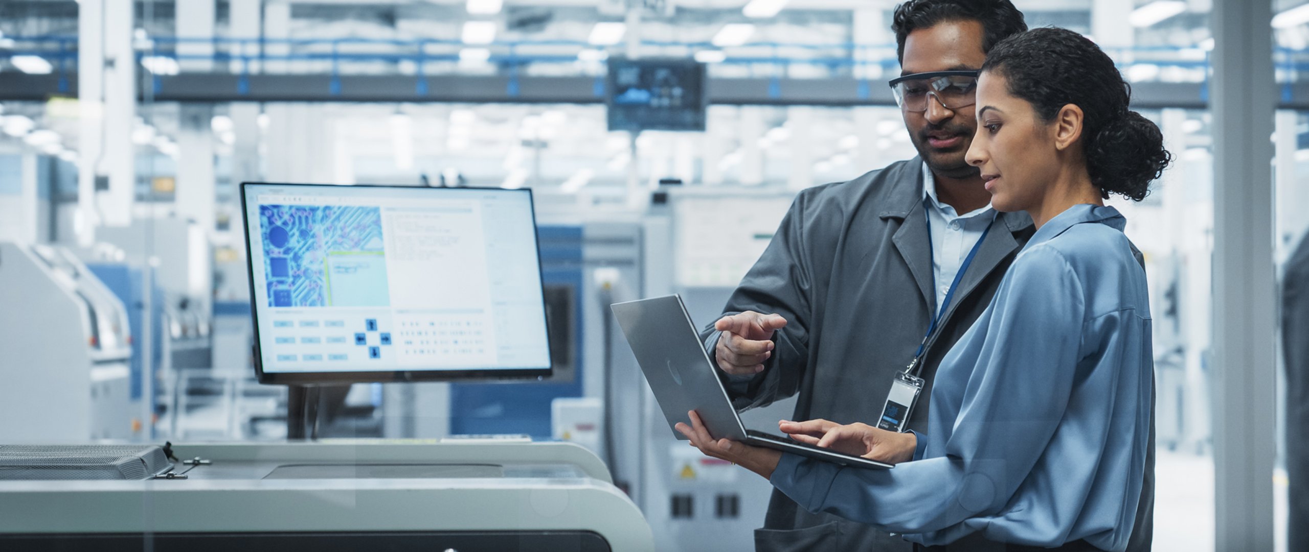 Male and female engineer employees collaborating on computer