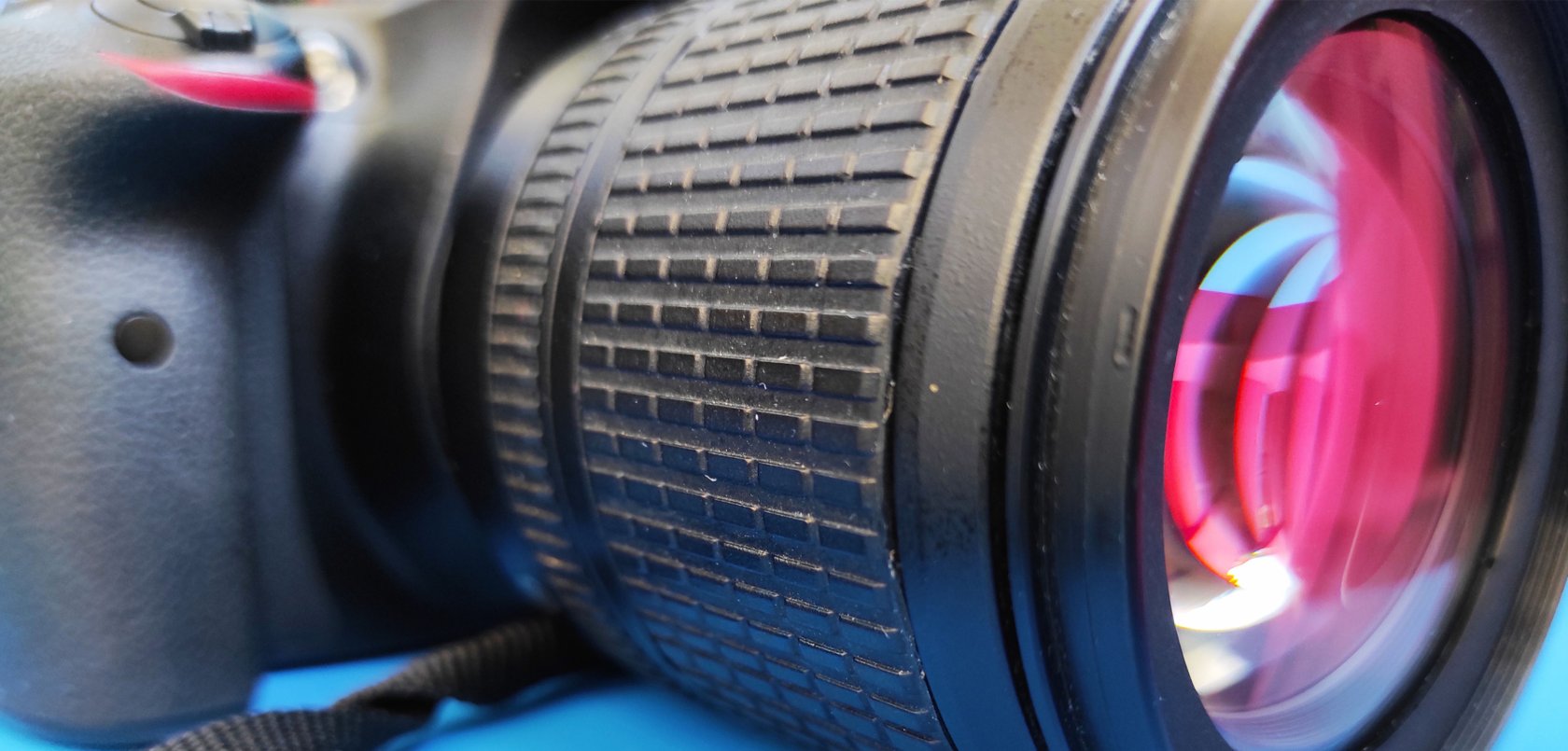 Close-up of a precision optical lens with textured focus ring and reflective glass elements, showcasing advanced imaging technology and high-performance optics.